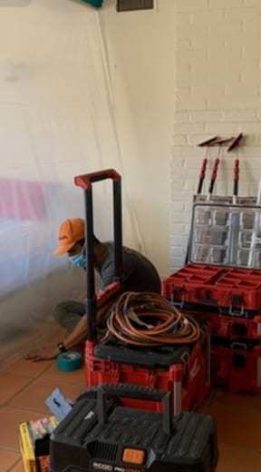 Technician setting up tools inside plastic containment