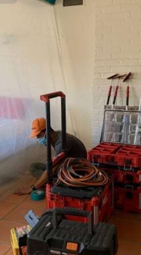 Technician setting up tools inside plastic containment